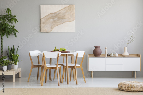 Cuadros en Lienzo Real photo of Scandi dining room interior with vases on cupboard, chairs standin