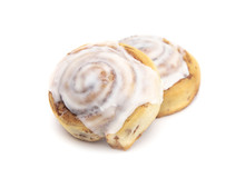Two Frosted Cinnamon Rolls On A White Background