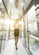 © xartproduction - successful and young businesswoman in the elevator business center rides to work