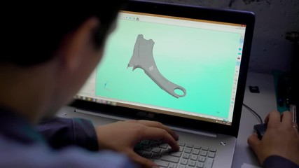 Close-up of the Engineer Holding Laptop with CAD Component Model on Screen.