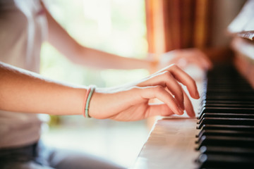 Junges Mädchen spielt leidenschaftlich auf Klavier, Ausschnitt der Hände