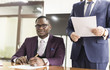 © xartproduction - African american man signing contract, black man hand putting signature on official document, biracial clients customers couple make purchase or sign prenuptial agreement concept