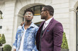 © xartproduction - two young and stylish African American men in the city smiling and talking. father and adult son relationship
