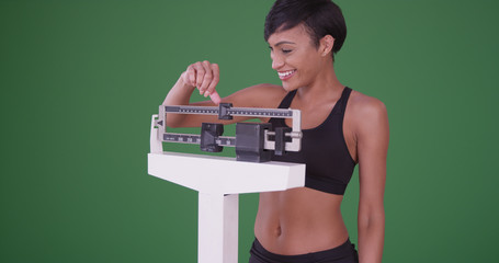 Healthy young black woman happy about weight loss on green screen