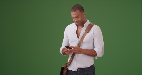 A young black man using mobile phone on green screen