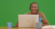 © Mark Adams - Old black woman sitting at desk with laptop smiling at camera on green screen