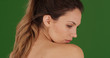 Attractive young model looking over shoulder posing for camera on green screen