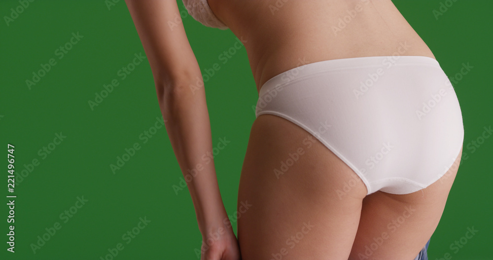 Rear view closeup of woman in underwear bending over on green screen