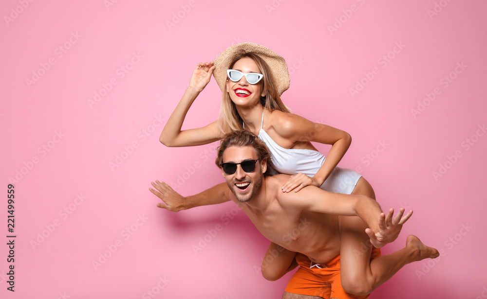 Happy young couple in beachwear on color background. Space for text - obrazy, fototapety, plakaty 