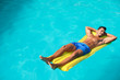 © New Africa - Young man with inflatable mattress in pool on sunny day