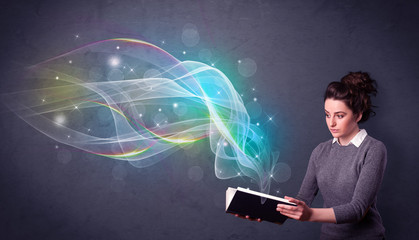 Poster - Casual young woman holding book with rainbow waves flying out of it