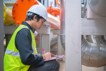 Asian Maintenance engineer at the waste water management system of a huge factory,maintenance checking technical data of heating system equipment,Thailand people