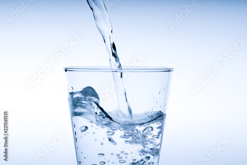 Fotografía Close up pouring drinking water into glass, studio shot