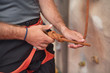 © herraez - Rock wall climber wearing safety harness and climbing equipment indoor, close-up image