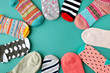 Many socks are piled in a circle. View from above. Many multicolored socks are made in the shape of a circle or sun. There is space for text. Clothes made of knitwear.