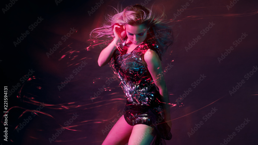Bright and stylish young woman dancing in club, color light, motion effects - obrazy, fototapety, plakaty 