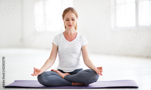 woman practicing yoga and meditating in lotus position Poster Mural XXL