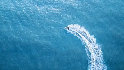 Wall Mural - scooter at the sea surface. aerial view of luxury floating boat on transparent turquoise water at su