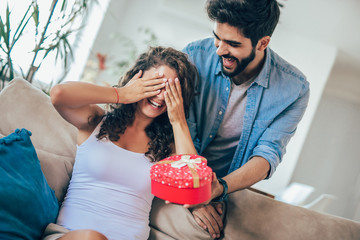 Wall Mural - Man giving a surprise gift to woman at home