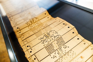 Closeup of perforated punched tape, history of computer information carrier