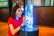 © EdNurg - Woman visitor looking at Colorful plasma lamp experiment in physics museum