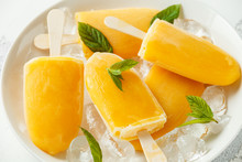 Popsicles, Ice Lollies On Stick With Sweet Orange Juice In White Plate With Ice