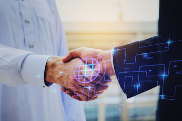 Wall Mural - close up hand of young Arabian man in white suit handshake after finishing up meeting with graphic network diagram, partnership, teamwork, technology, connection, financial and investment concept
