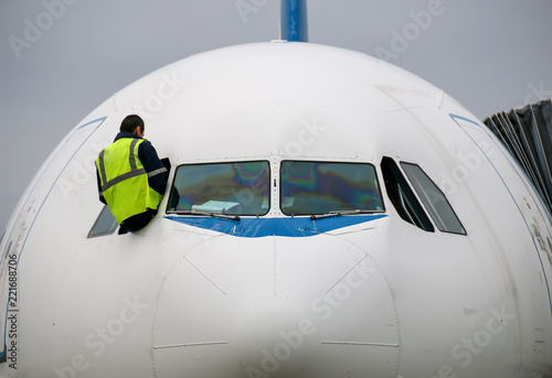 Fotografie, Obraz Technicien inspectant les vitres d'un cockpit d'avion