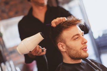 Handsome man at the hairdresser getting a new haircut