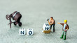 © jan_S - Adding white cube with letter w to the word no creating new word now on grey background with miniature figurines