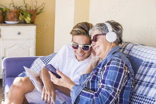 Fotografie, Obraz couple young and old grandmother and teenager nephew family time together listen music with earphones and enjoy the day