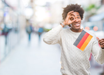 Wall Mural - afro american man flag of germany over isolated background with happy face smiling doing ok sign wit
