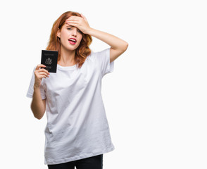 Canvas Print - Young beautiful woman holding passport of united states of america over isolated background stressed with hand on head, shocked with shame and surprise face, angry and frustrated. Fear and upset