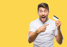 Young Handsome Man Holding Credit Card Over Isolated Background Very Happy Pointing With Hand And Finger