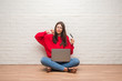 © Krakenimages.com - Young brunette woman sitting on the floor over white brick wall paying holding credit card with angry face, negative sign showing dislike with thumbs down, rejection concept