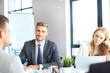© ty - Business people in discussing something while sitting together at the table.