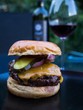 Hommade burger with bottle and glass of red wine in the background