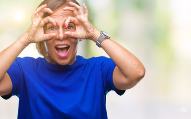 Poster - Middle age senior hispanic woman over isolated background doing ok gesture like binoculars sticking tongue out, eyes looking through fingers. Crazy expression.