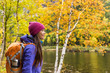 © Maridav - Woman hiker hiking looking at scenic view of fall foliage mountain landscape . Adventure travel outdoors person standing relaxing near river during nature hike in autumn season.