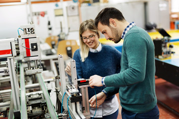 Young attractive students of mechatronics working on project