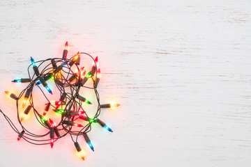Wall Mural - christmas lights bulb decoration on white wood. merry christmas and new year holiday background. top