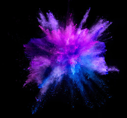 Wall Mural - Explosion of coloured powder isolated on black background.