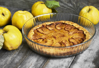 Homemade apple quince pie with fresh fruits on rustic wooden background. Top view