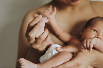 Wall Mural - naked mother holding her infant baby