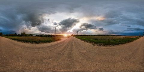 Wall Mural - full seamless spherical panorama 360 degrees angle view on gravel road among fields in evening sunse
