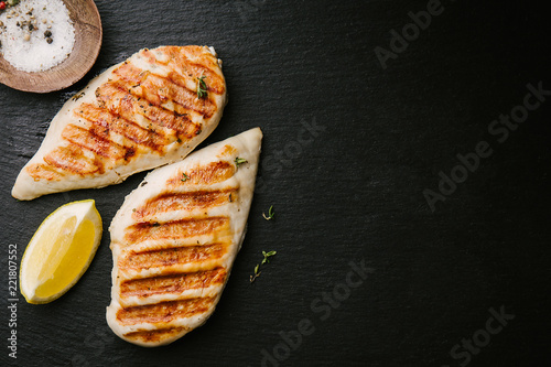 Fotomural Grilled chicken breast served on black slate