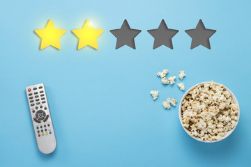 Bowl of popcorn and a remote from the TV set on a blue backgroun