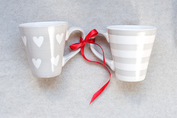 Two cups of gray color on a fabric background