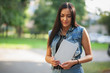 © aleksandr_yu - Young pretty brunette girl with the tablet and listening to music on the street in summer.