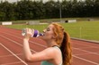© Wavebreak Media - Female athletic drinking water on running track